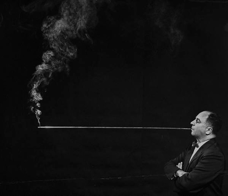 man smoking cigarette through a four-foot-long holder